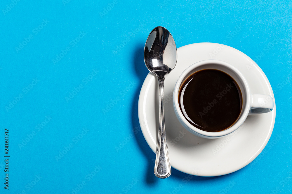 Tazza di caffè con cucchiaino su sfondo azzurro Tazza di caffè con cucchiaino su sfondo azzurro