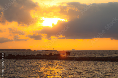 Dramatic orange sunset over the sea with a yacht
