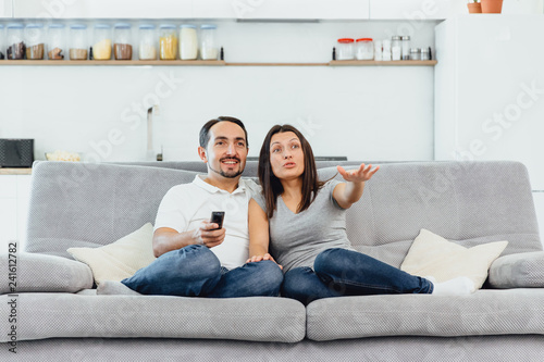 A woman and a man watch TV