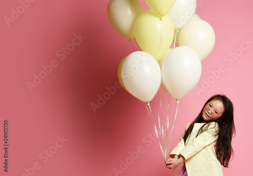Little asian baby girl in yellow fashion jacket and purple dress with balloons celebrate happy smiling