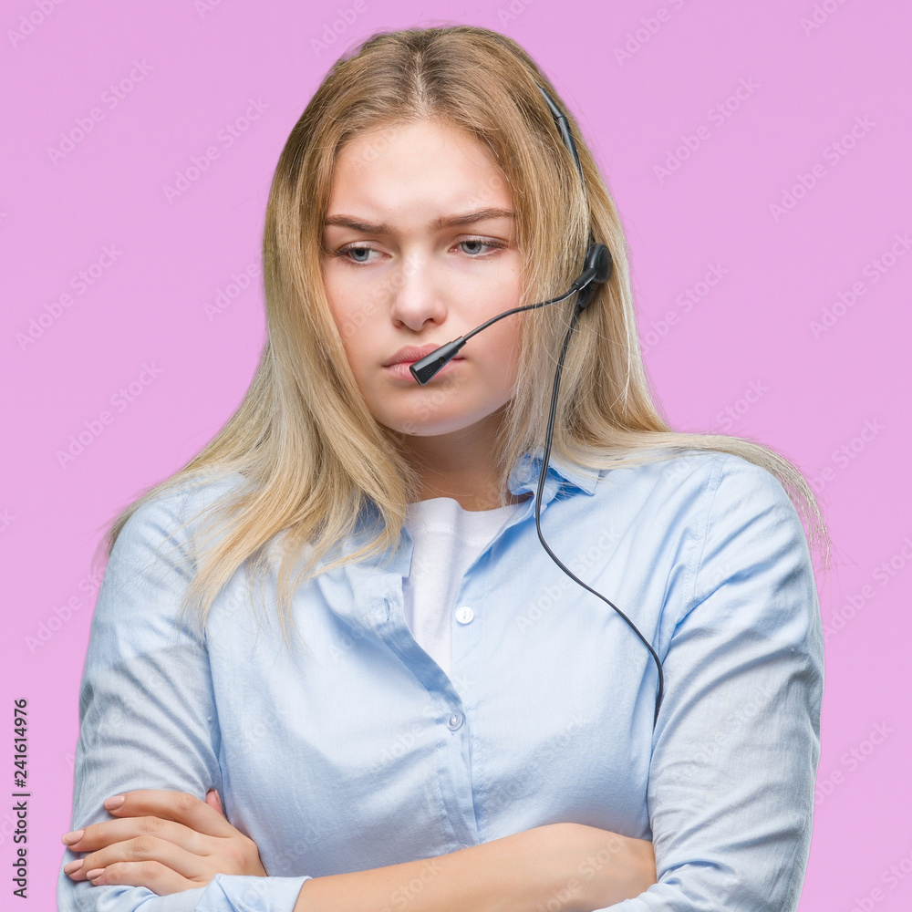 Young caucasian business woman wearing call center headset over isolated background skeptic and nervous, disapproving expression on face with crossed arms. Negative person. Young caucasian business woman wearing call center headset over isolated background skeptic and nervous, disapproving expression on face with crossed arms. Negative person.