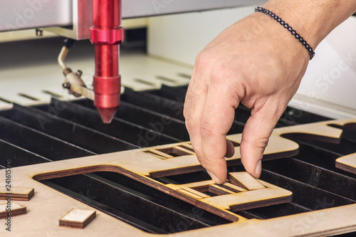 Slika na platnu Laser engraver working and engraving wooden board with hand