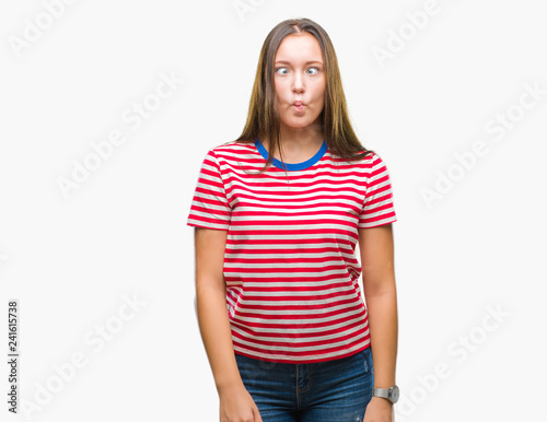 Young caucasian beautiful woman over isolated background making fish face with lips, crazy and comical gesture. Funny expression.