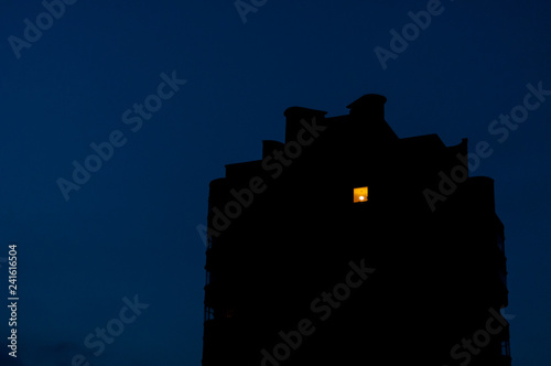 Night view on old residential building where the light in on only in one room
