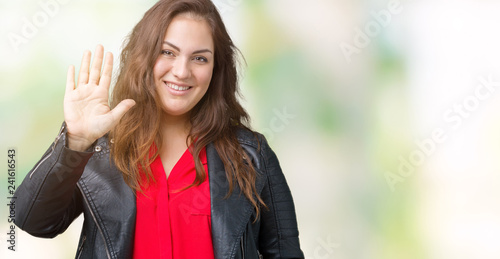 Beautiful plus size young woman wearing a fashion leather jacket over isolated background Waiving saying hello happy and smiling, friendly welcome gesture