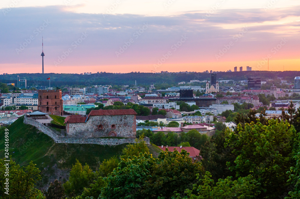 Cityscape skyline view on famous Gediminas castle complex and tv tower on the background from Three Crosses Hill panoramic viewpoint at sunset