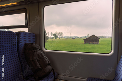 Backpack on train seats and a landscape window view photo