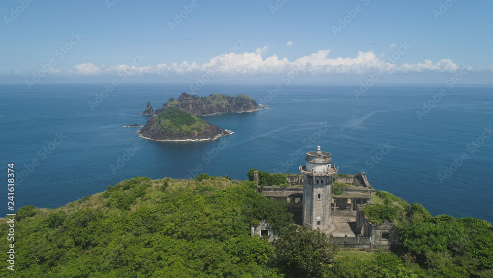 Aerial view of lighthouse in Palau island. Lighthouse in cape Engano against blue sky and rocky islands, province of Cagayan, Philippines.
