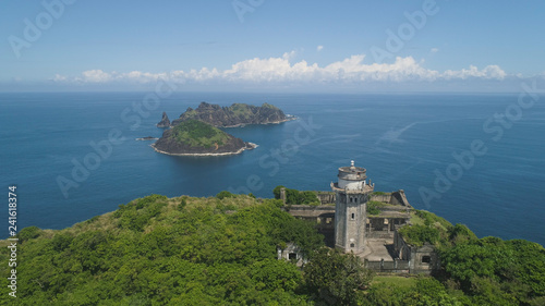 Aerial view of lighthouse in Palau island. Lighthouse in cape Engano against blue sky and rocky islands, province of Cagayan, Philippines.
