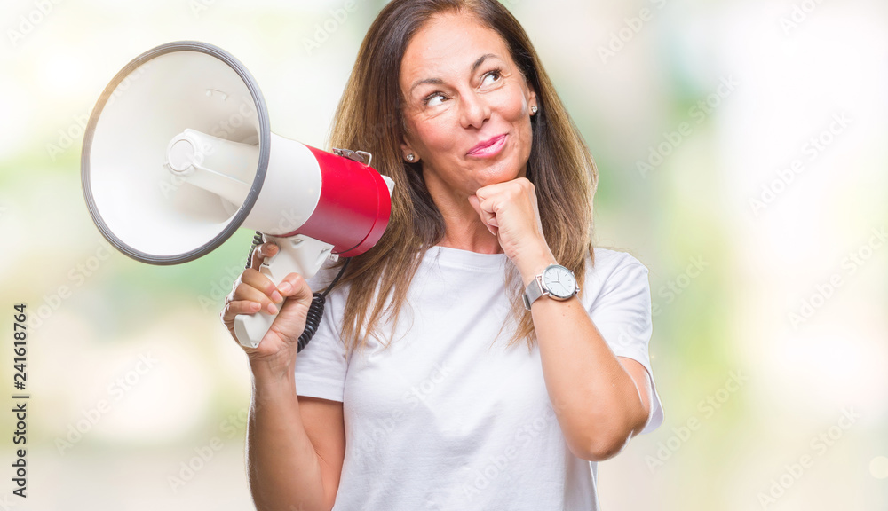 Middle age hispanic woman yelling through megaphone over isolated background serious face thinking about question, very confused idea Middle age hispanic woman yelling through megaphone over isolated background serious face thinking about question, very confused idea