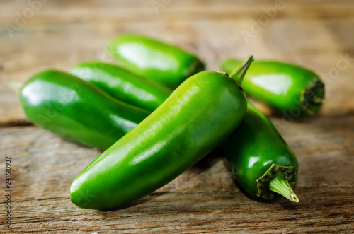 Fresh jalapeno peppers on a dark wood background