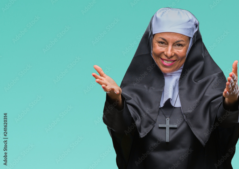Middle age senior christian catholic nun woman over isolated background looking at the camera smiling with open arms for hug. Cheerful expression embracing happiness. Middle age senior christian catholic nun woman over isolated background looking at the camera smiling with open arms for hug. Cheerful expression embracing happiness.