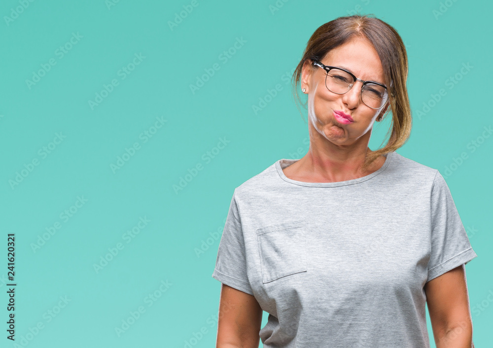 Middle age senior hispanic woman wearing glasses over isolated background puffing cheeks with funny face. Mouth inflated with air, crazy expression. Middle age senior hispanic woman wearing glasses over isolated background puffing cheeks with funny face. Mouth inflated with air, crazy expression.