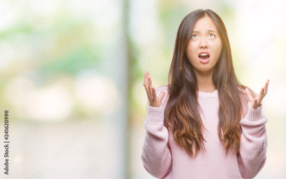 Young asian woman over isolated background crazy and mad shouting and yelling with aggressive expression and arms raised. Frustration concept. Young asian woman over isolated background crazy and mad shouting and yelling with aggressive expression and arms raised. Frustration concept.