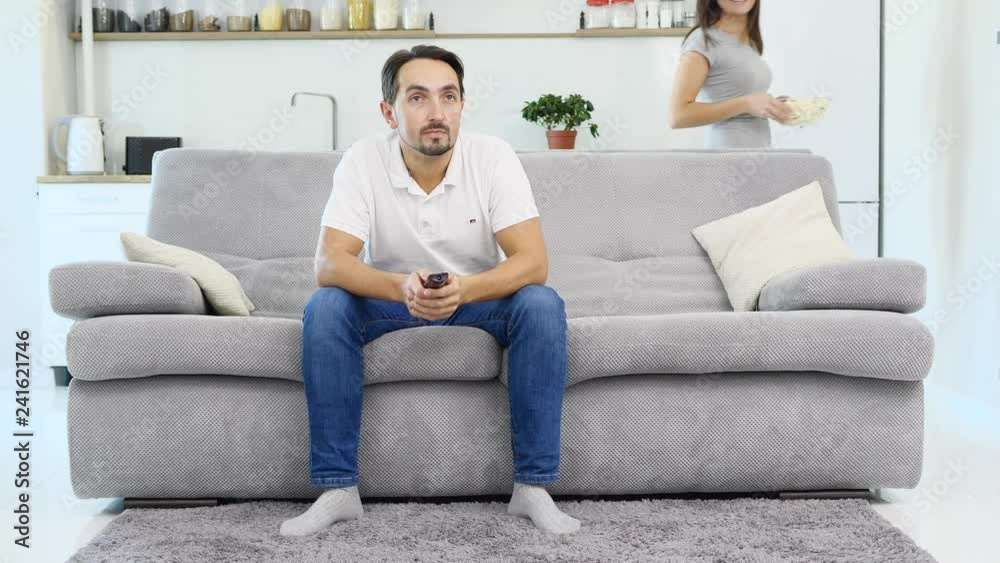 A man and his wife watching TV and eating popcorn A man and his wife watching TV and eating popcorn