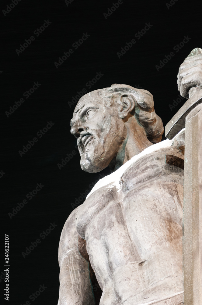 The architectural symbol is a monument. Part of the monument, a bust on a black winter background. Contrast photo.