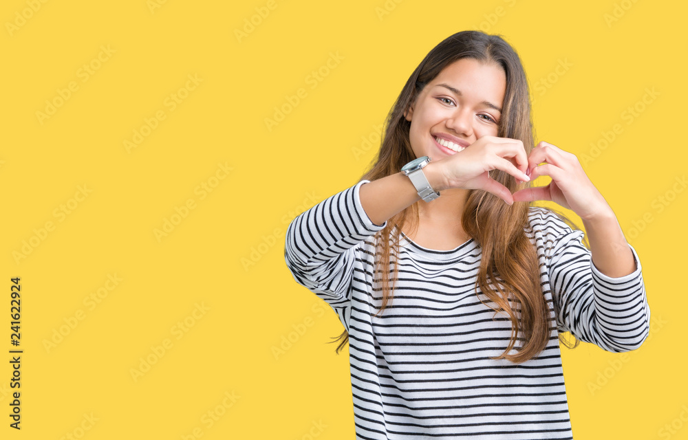 Young beautiful brunette woman wearing stripes sweater over isolated background smiling in love showing heart symbol and shape with hands. Romantic concept. Young beautiful brunette woman wearing stripes sweater over isolated background smiling in love showing heart symbol and shape with hands. Romantic concept.