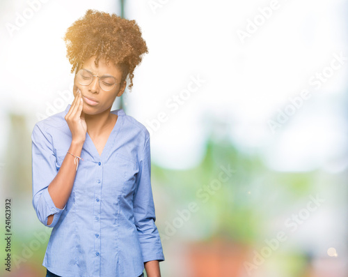 Beautiful young african american business woman over isolated background touching mouth with hand with painful expression because of toothache or dental illness on teeth. Dentist concept.