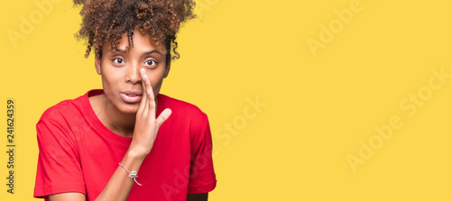 Beautiful young african american woman over isolated background hand on mouth telling secret rumor, whispering malicious talk conversation photo