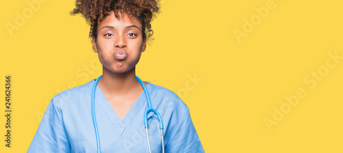 Tableau sur toile Young african american doctor woman over isolated background puffing cheeks with funny face