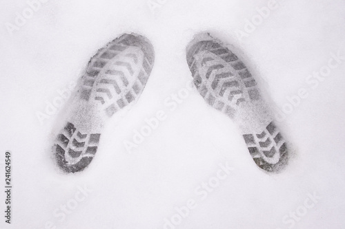 two shoe prints on snow, top view, copy space, cloudy, no sunshi