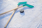 hockey stick and puck on the ice on sunny winter day.winter sports for outdoor activities.hockey puck and stick laying on the textured ice close up copyspace.Young hockey player practising on a frozen