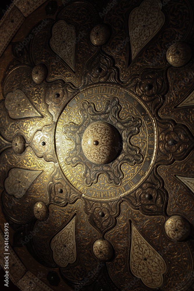 gold patterns on old armor, Ancient shield close to gold patterns on old armor, Ancient shield close to