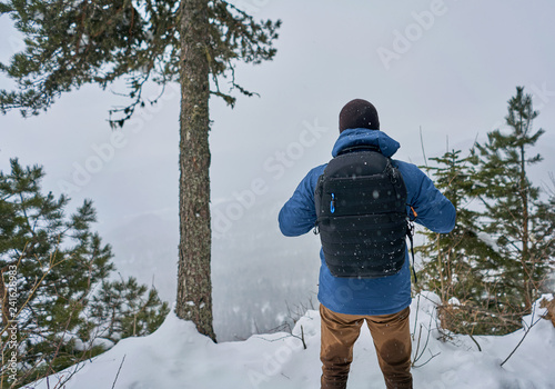 man with a backpack on top of a snowy mountain