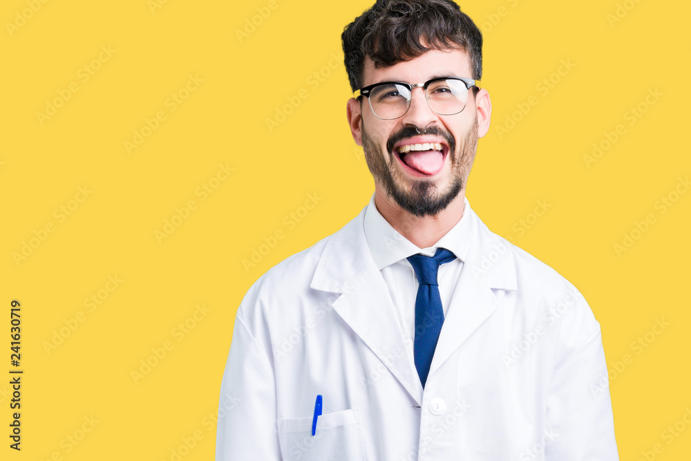 Young professional scientist man wearing white coat over isolated background sticking tongue out happy with funny expression. Emotion concept. Young professional scientist man wearing white coat over isolated background sticking tongue out happy with funny expression. Emotion concept.