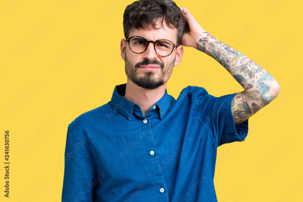Young handsome man wearing glasses over isolated background confuse and wonder about question. Uncertain with doubt, thinking with hand on head. Pensive concept. Young handsome man wearing glasses over isolated background confuse and wonder about question. Uncertain with doubt, thinking with hand on head. Pensive concept.