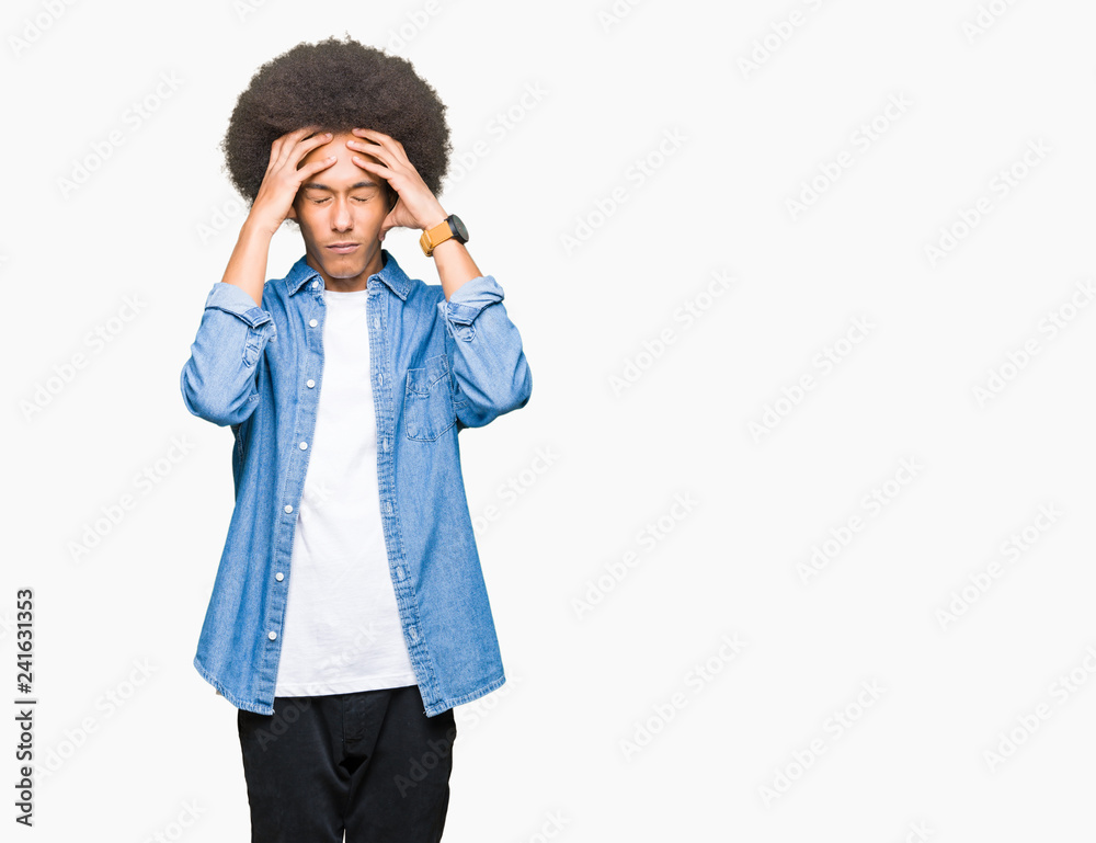 Young african american man with afro hair suffering from headache desperate and stressed because pain and migraine. Hands on head. Young african american man with afro hair suffering from headache desperate and stressed because pain and migraine. Hands on head.