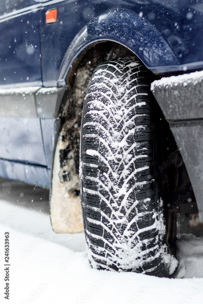 Winter is snowing. car wheel winter tires. close-up. have toning