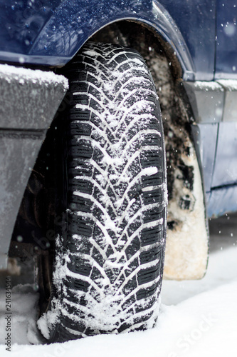 Winter is snowing. car wheel winter tires. close-up. have toning © sir270