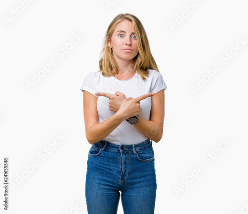 Beautiful young woman wearing casual white t-shirt over isolated background Pointing to both sides with fingers, different direction disagree