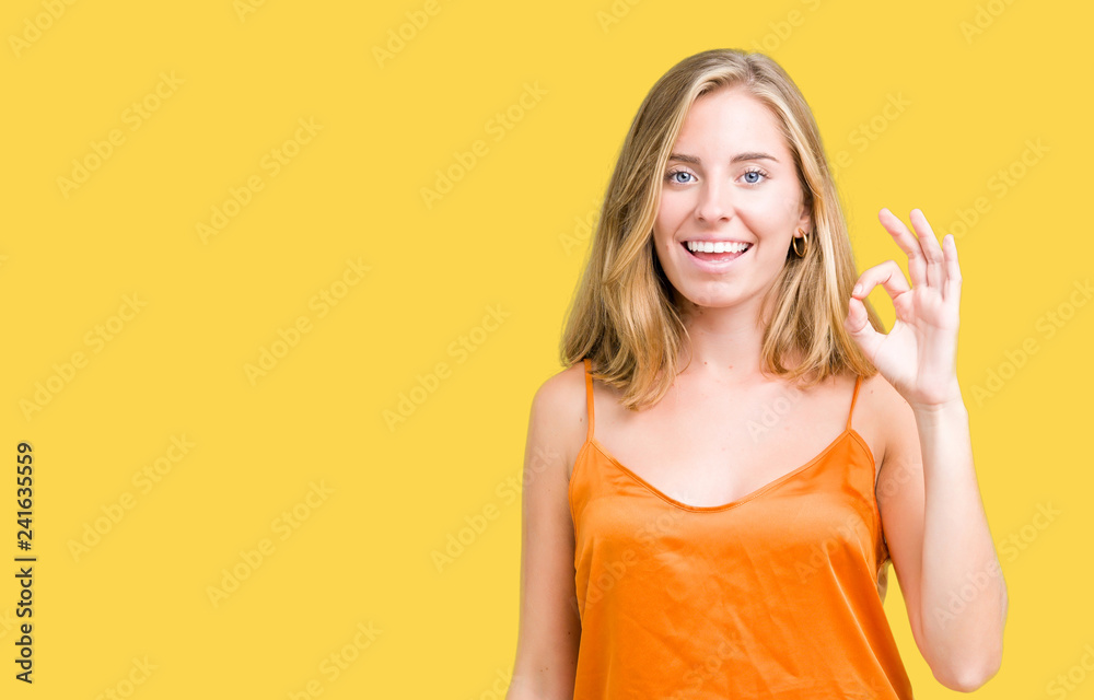 Beautiful young woman wearing orange shirt over isolated background smiling positive doing ok sign with hand and fingers. Successful expression. Beautiful young woman wearing orange shirt over isolated background smiling positive doing ok sign with hand and fingers. Successful expression.