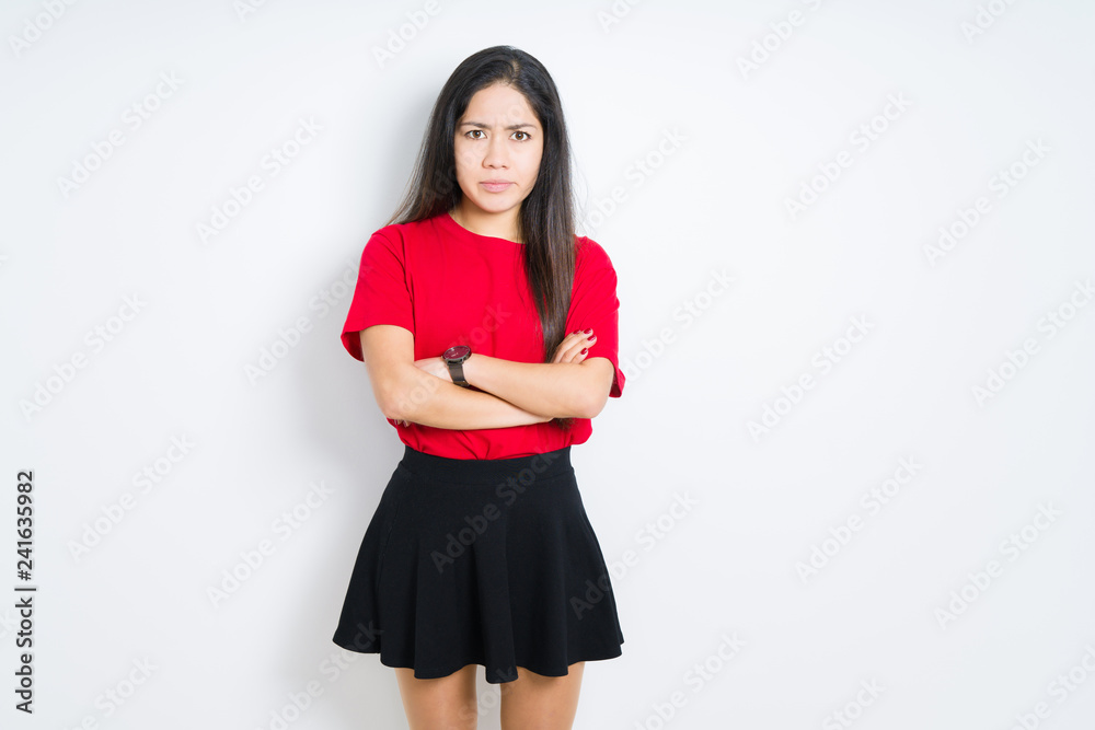 Beautiful brunette woman wearing red t-shirt and skirt over isolated background skeptic and nervous, disapproving expression on face with crossed arms. Negative person. Beautiful brunette woman wearing red t-shirt and skirt over isolated background skeptic and nervous, disapproving expression on face with crossed arms. Negative person.