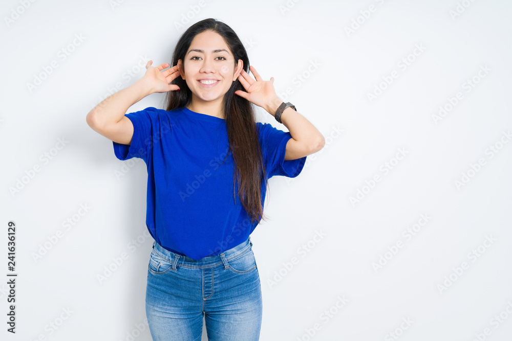 Beautiful brunette woman over isolated background Smiling pulling ears with fingers, funny gesture. Audition problem Beautiful brunette woman over isolated background Smiling pulling ears with fingers, funny gesture. Audition problem