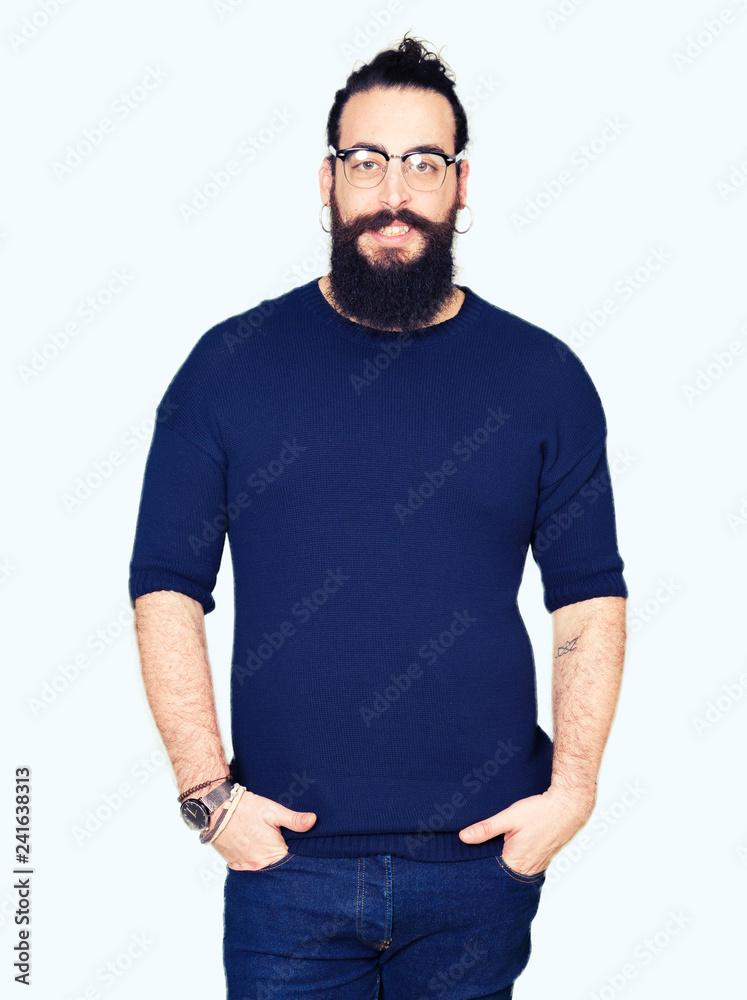 Fototapeta premium Young hipster man with long hair and beard wearing glasses with a happy and cool smile on face. Lucky person.