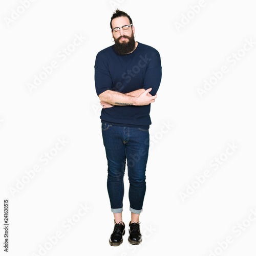 Young hipster man with long hair and beard wearing glasses with hand on stomach because nausea, painful disease feeling unwell. Ache concept.