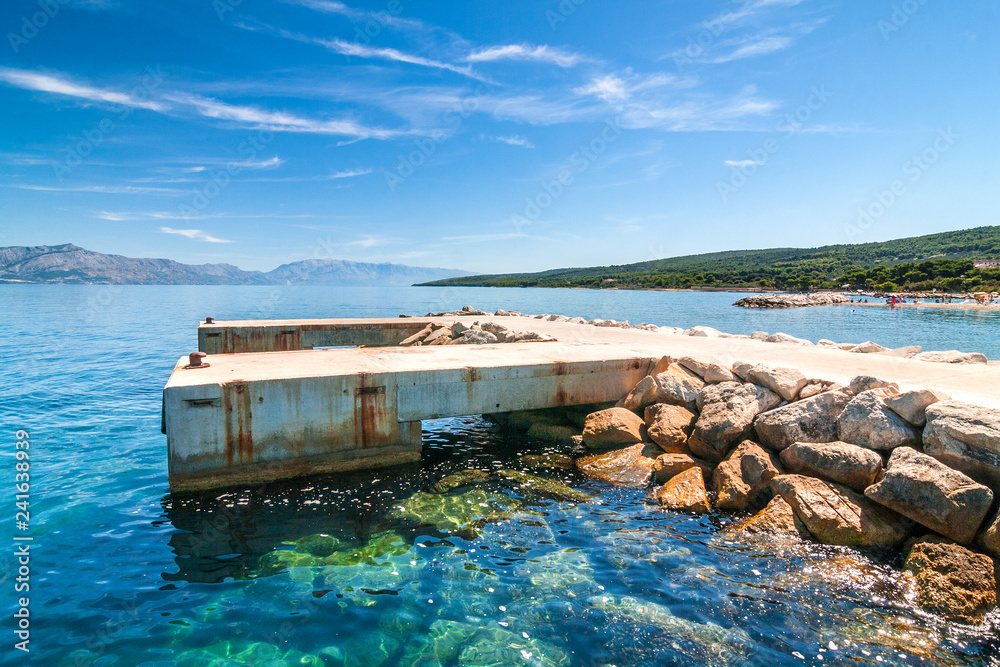 Concrete pier for ships in the Supetar harbor on the Brac island at a summer, Croatia, Europe.