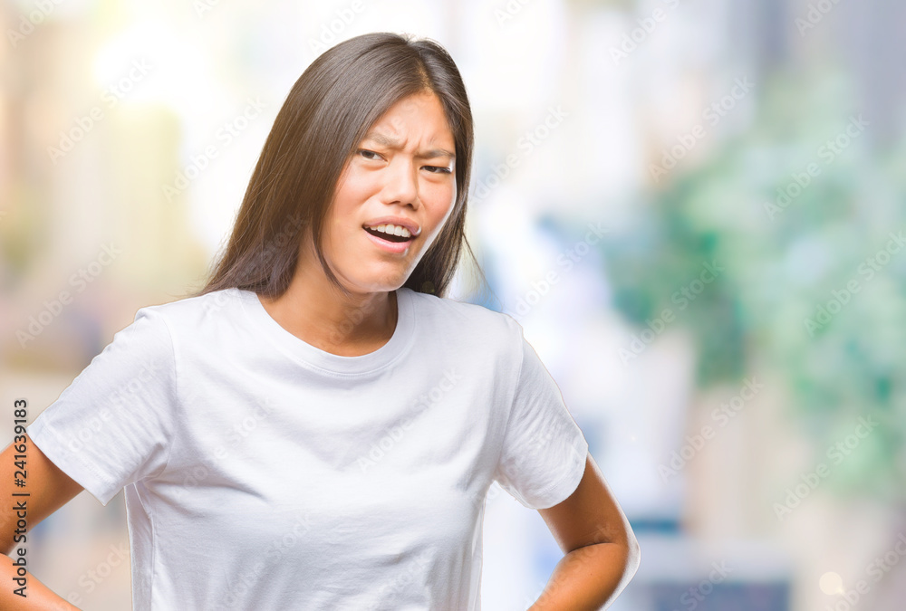 Young asian woman over isolated background with hand on stomach because indigestion, painful illness feeling unwell. Ache concept. Young asian woman over isolated background with hand on stomach because indigestion, painful illness feeling unwell. Ache concept.
