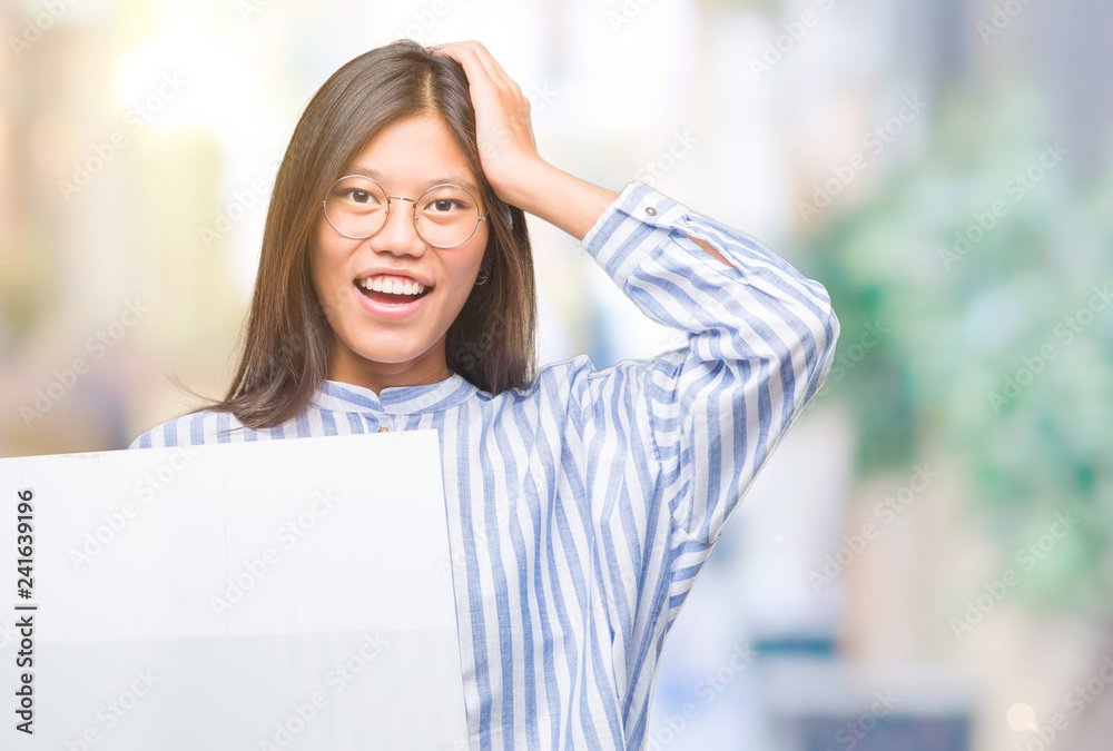 Young asian woman over isolated background holding blank banner stressed with hand on head, shocked with shame and surprise face, angry and frustrated. Fear and upset for mistake. Young asian woman over isolated background holding blank banner stressed with hand on head, shocked with shame and surprise face, angry and frustrated. Fear and upset for mistake.
