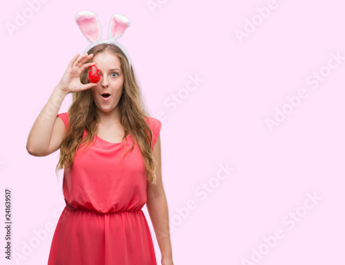 Young blonde woman wearing easter bunny ears scared in shock with a surprise face, afraid and excited with fear expression