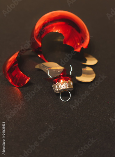 Obraz na plátne Close up view of a red glass Christmas ball or babble broken on a black background