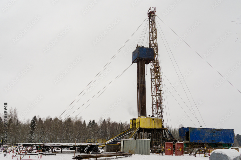 Oil and Gas Drilling Rig onshore dessert with dramatic cloudscape. Oil drilling rig operation on the oil platform in oil and gas industry. Land oil drilling rig blue sky