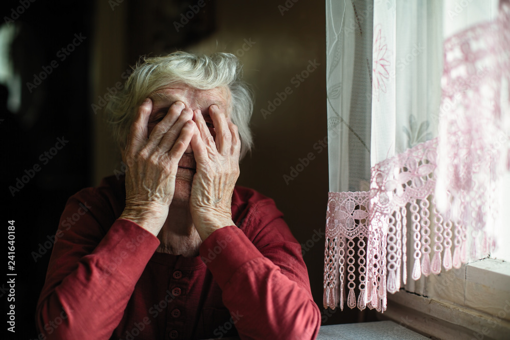 Emotions of elderly woman sitting at the table. 90 year old.
