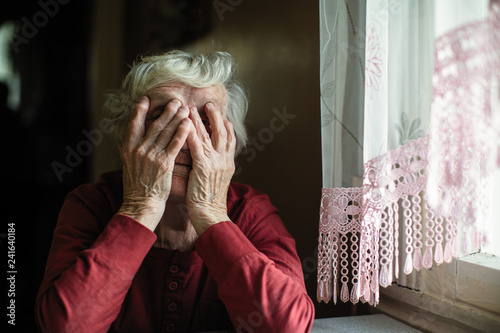 Obraz na płótnie Emotions of elderly woman sitting at the table. 90 year old. w salonie