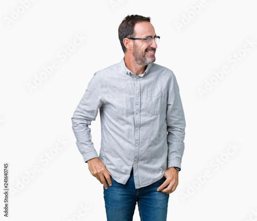 Handsome middle age elegant senior man wearing glasses over isolated background looking away to side with smile on face, natural expression. Laughing confident. © Krakenimages.com