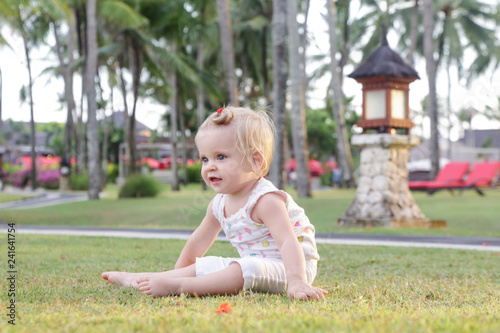 Adorable blonde baby on the lawn, summertime outdoor activity © triocean