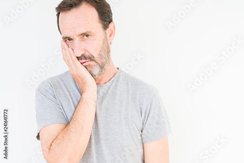 Handsome senior man over isolated background thinking looking tired and bored with depression problems with crossed arms.